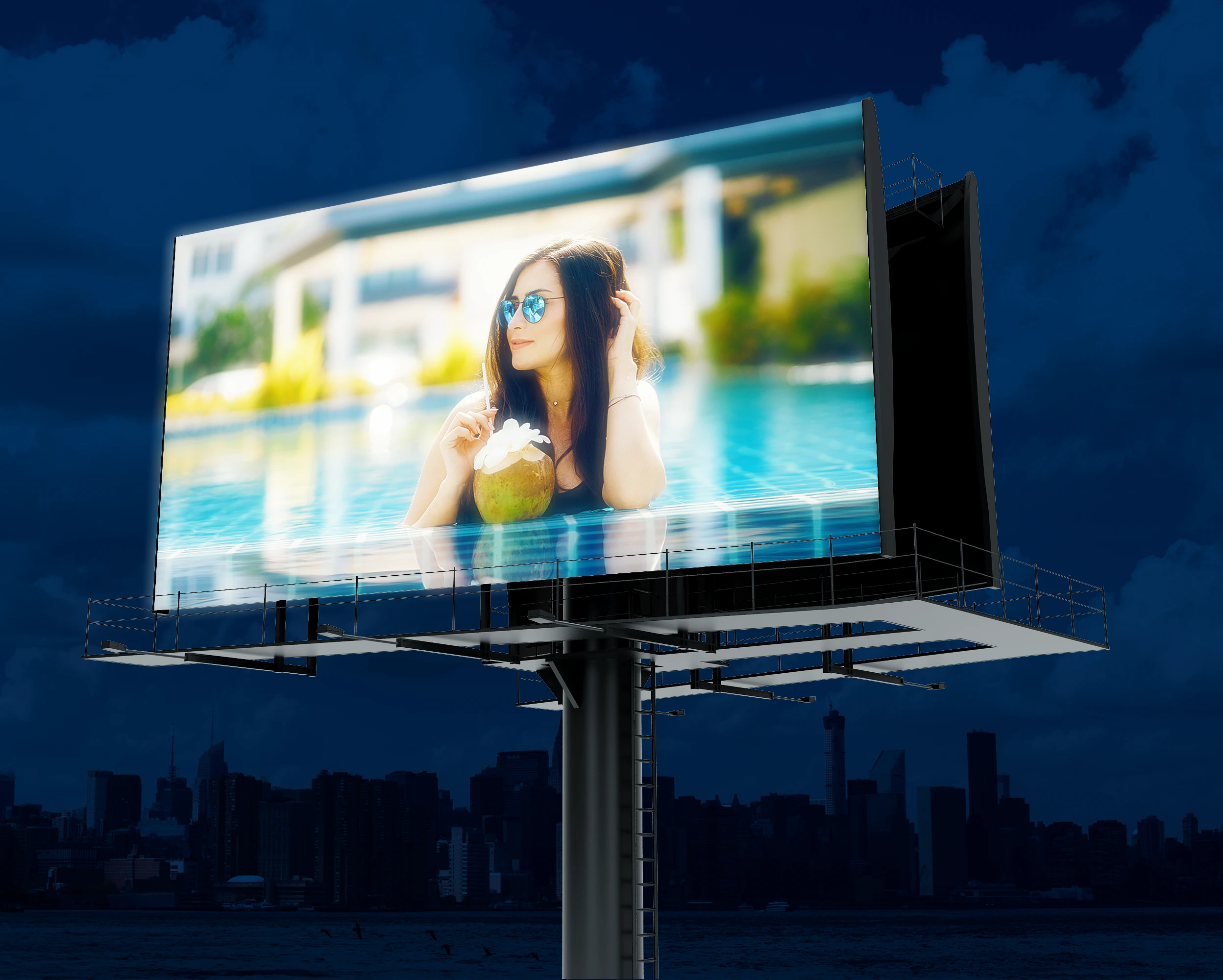 Stałoformatowy billboard z podświetlaną reklamą zamontowany na wysokim słupie nocą.