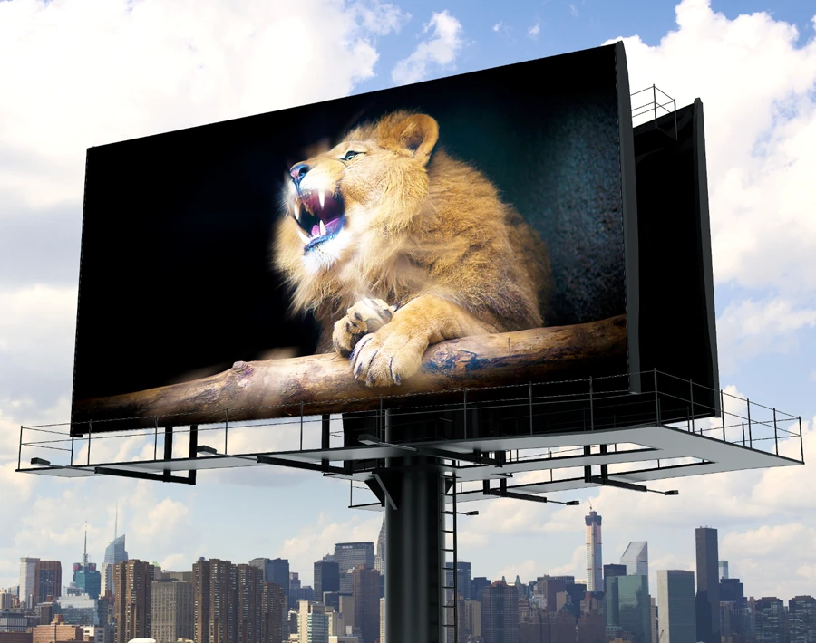 Stałoformatowy billboard z reklamą przedstawiającą lwa, ustawiony na wysokim słupie w mieście.