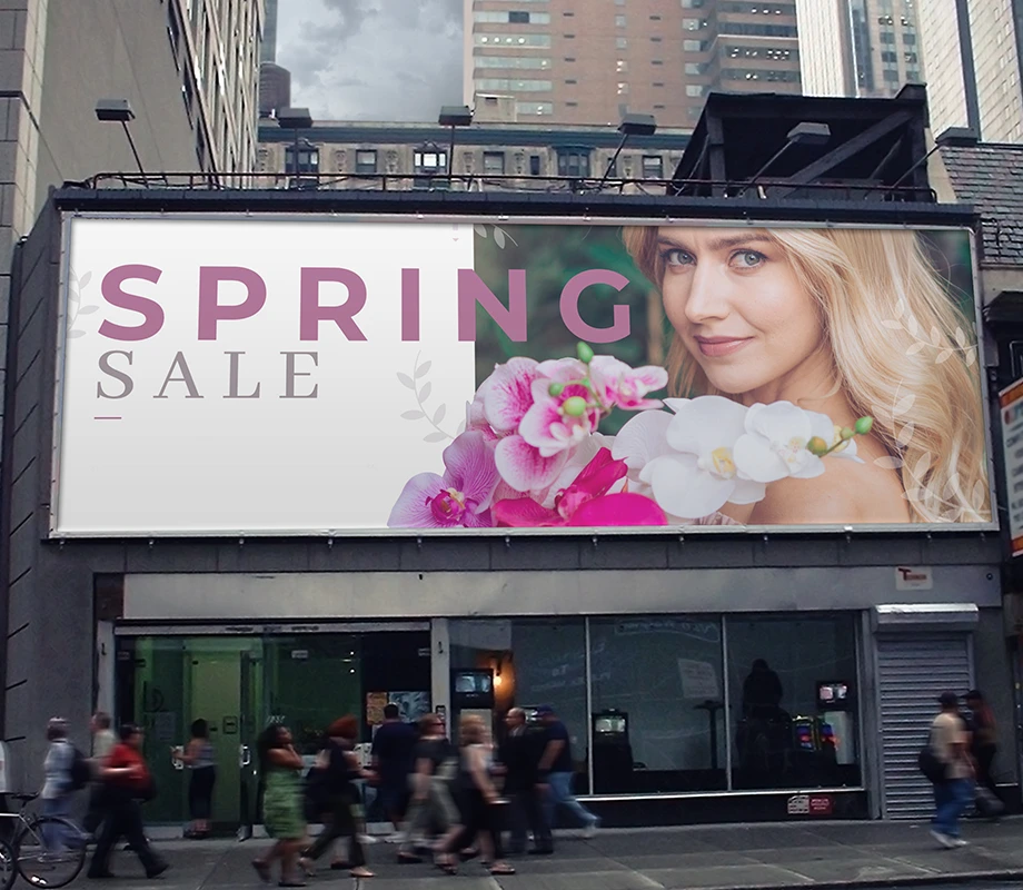 Wielkoformatowy baner reklamowy z grafiką promocyjną „Spring Sale” umieszczony na fasadzie budynku.