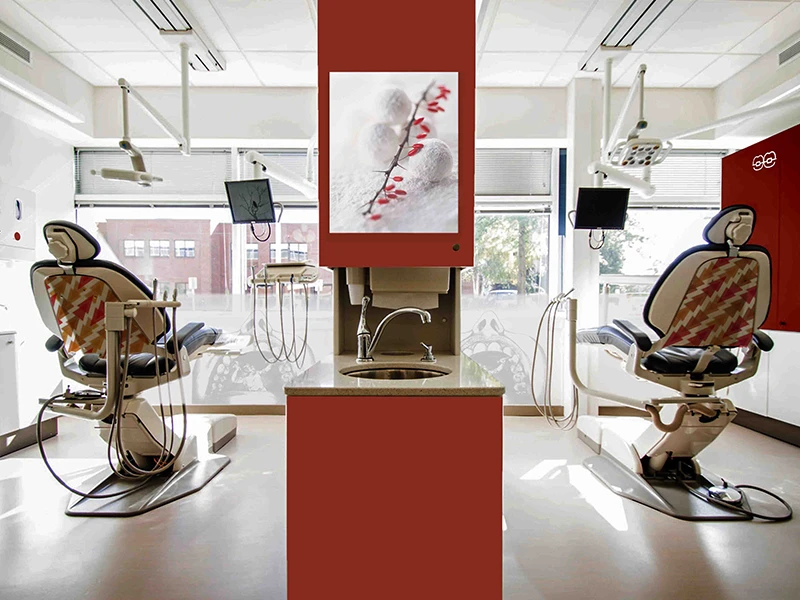 Nowoczesne stanowisko fryzjerskie z dwoma fotelami i lustrem w jasnym salonie.