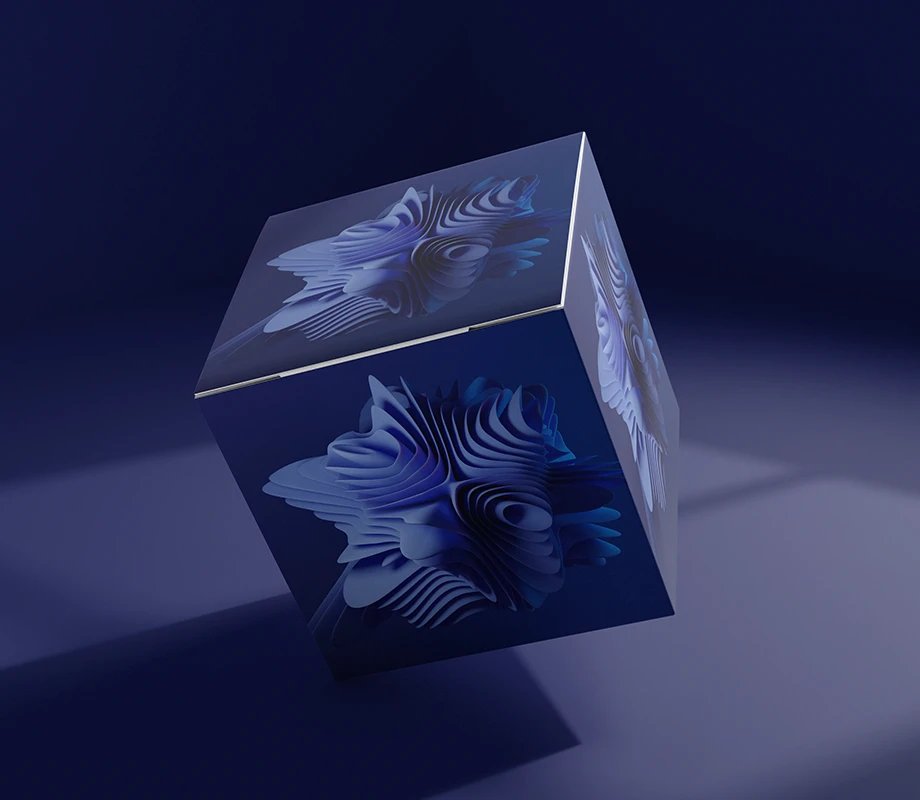 Sześcienna pufa z kolorowym nadrukiem stoi na jednolitym, ciemnym tle.