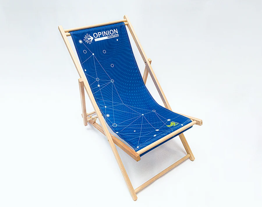 Drewniany leżak reklamowy z niebieskim siedziskiem z nadrukiem graficznym.