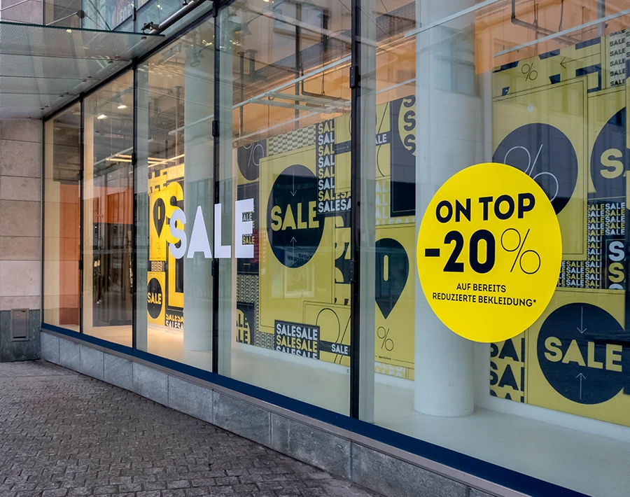 Witryna sklepu z dużymi okleinami promocyjnymi „SALE” i informacją o rabacie 20% na szybach.