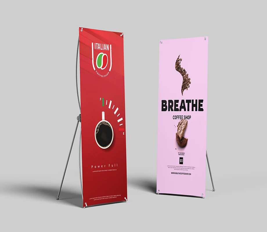 Dwa stojące roll-upy reklamowe z kolorowymi projektami graficznymi ustawione na jasnym tle.