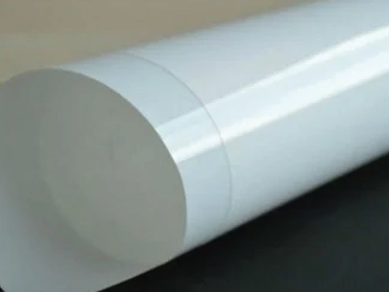 Biała folia PET zwinięta w rolkę z widoczną gładką, sztywną powierzchnią.