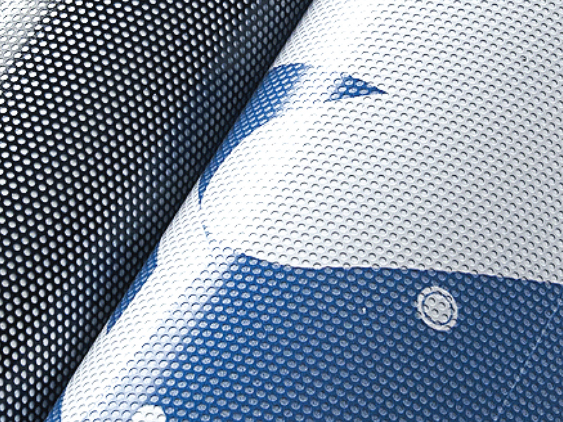 Biała folia One Way Vision z perforowaną strukturą, częściowo podwinięta, ukazująca drobne otwory.