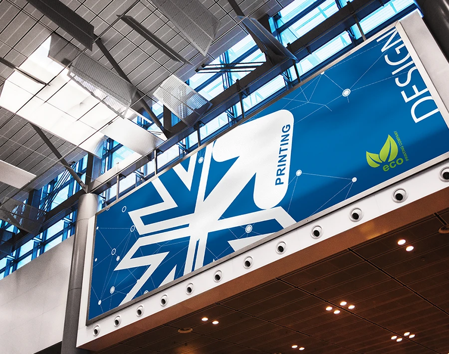 Wielkoformatowy baner reklamowy z niebieską grafiką zawieszony wewnątrz hali.