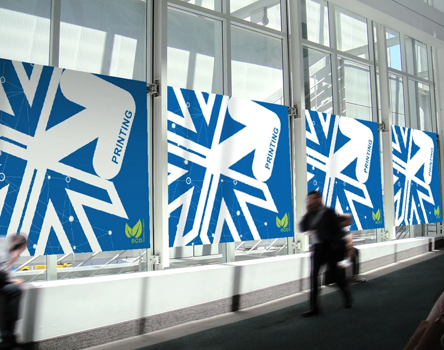 Dwustronna naklejka monomerowa z niebiesko-białą grafiką, aplikowana na szybach w ciągu komunikacyjnym.