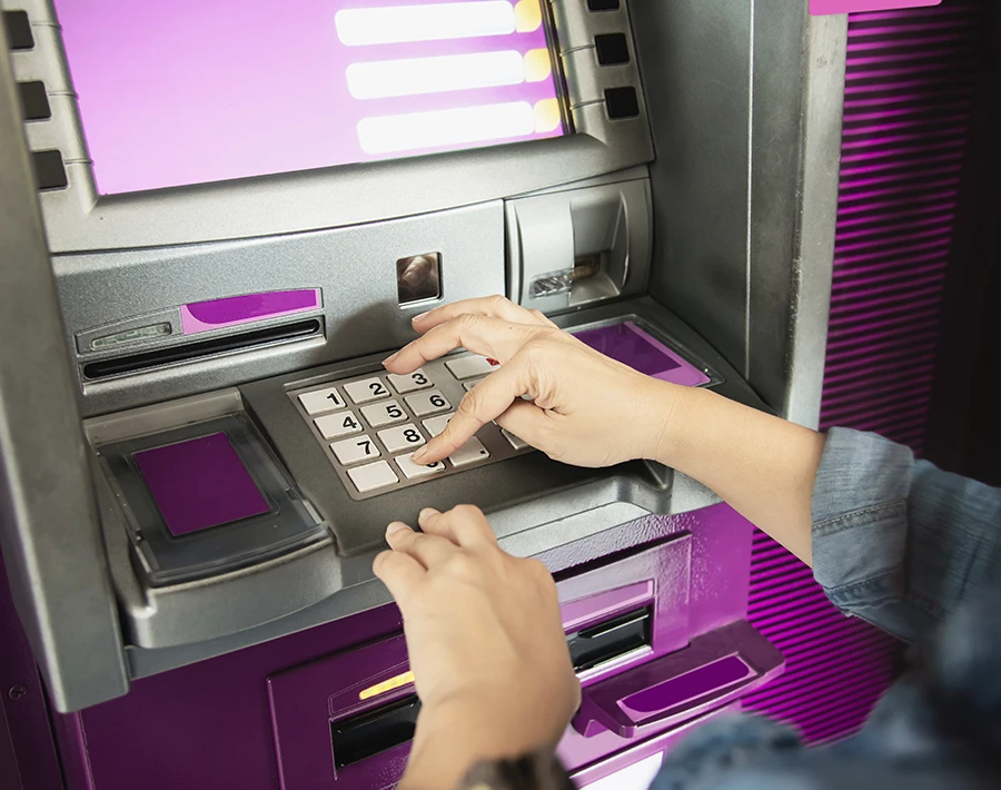 Dłonie umieszczają niewielki wydruk w urządzeniu drukującym z fioletowym podświetleniem.