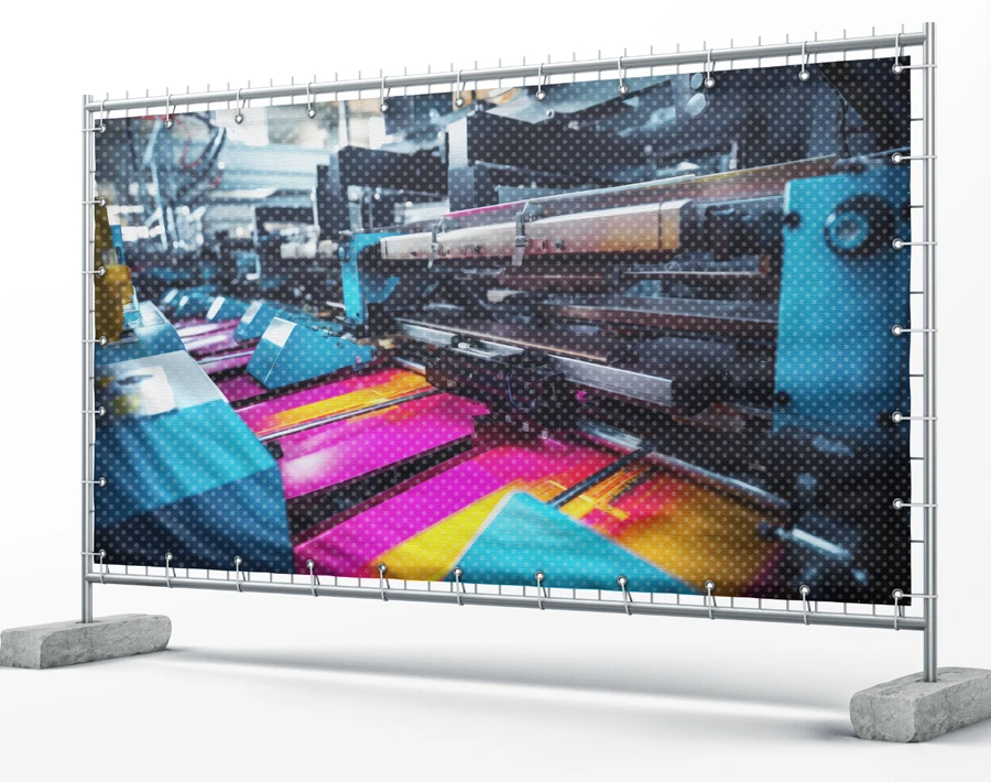 Baner budowlany z kolorową grafiką przemysłową, rozpięty na metalowej konstrukcji z obciążnikami.