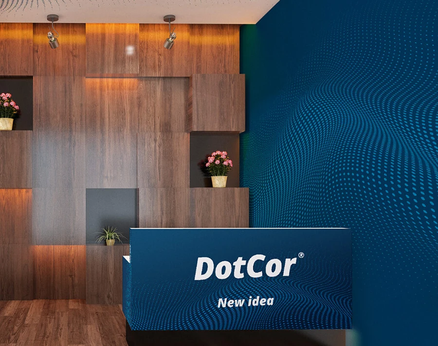 Niebieskie stoisko recepcyjne z ladą DotCor i dekoracyjną ścianą w tle.