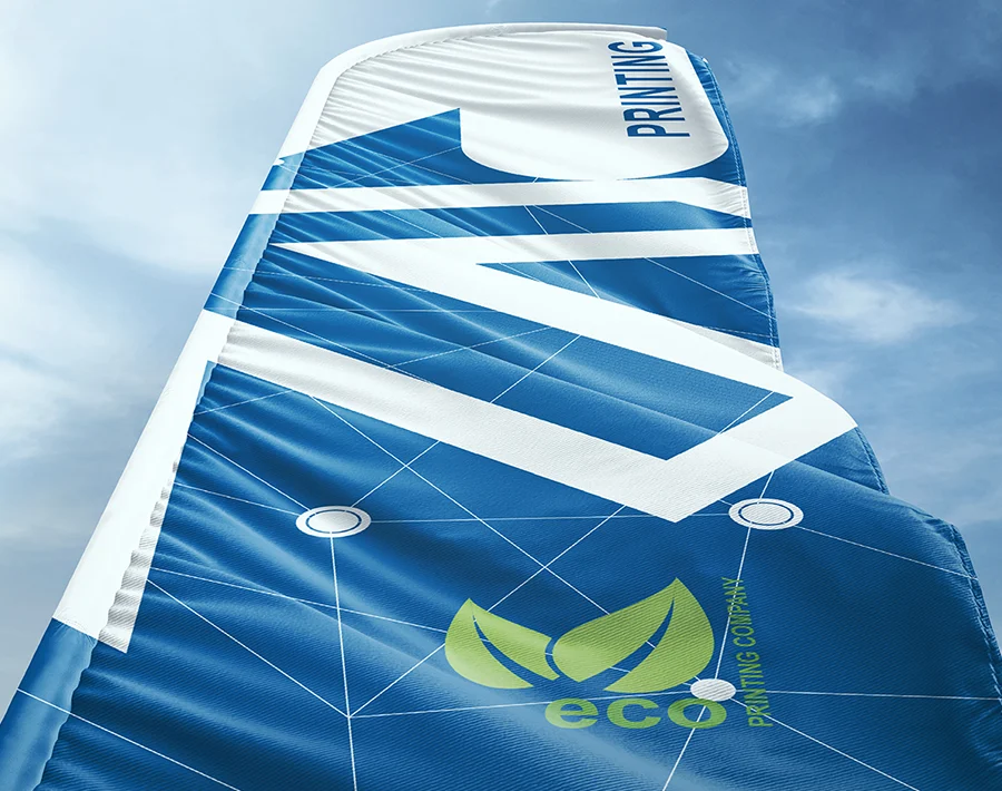 Niebieska flaga plażowa typu skrzydło z białą grafiką, powiewająca na tle nieba.