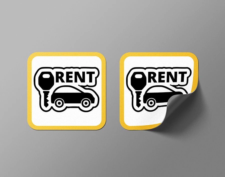 Biała naklejka magnetyczna z nadrukiem i podwiniętym rogiem, ukazująca elastyczną warstwę magnetyczną.