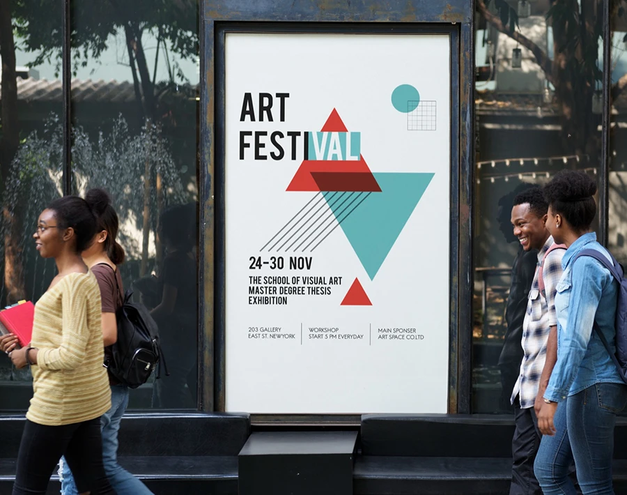 Reklama wydarzenia „Art Festival” na przystankowym citylightcie, obok którego przechodzą ludzie na ulicy.